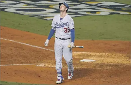  ?? Luis Sinco Los Angeles Times ?? CODY BELLINGER walks back to the dugout after striking out, for a World Series record 17th time, in the seventh inning of Game 7. The rookie was just one of the Dodgers’ big bats that went silent in the Fall Classic, failing to produce as they had this...