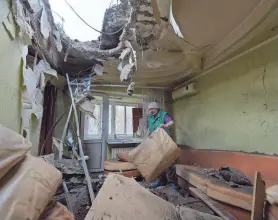  ?? AFP VIA GETTY IMAGES ?? A woman clears rubble in her daughter’s apartment after what officials called a Ukrainian strike in Donetsk, Russian-controlled Ukraine.