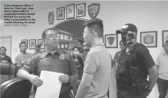  ?? MAE CLYDYL AVILA ?? Police Regional Office-7 director Chief Supt. Jose Mario Espino talks to suspected ecstasy dealer Richard Go during the latter’s presentati­on to the media following his arrest.