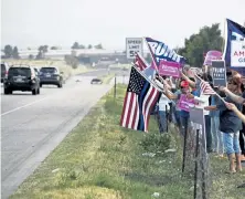  ?? Andy Cross, The Denver Post ?? Colorado Women for Trump wave flags and signs along Wadsworth Boulevard in Littleton in support of the Republican incumbent’s re- election Wednesday before an event to connect volunteers with supporters.