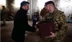  ?? — AFP photo ?? Zelensky (left) presents the Golden Star Order to Colonel Oleh Apostol, commander of the 95th separate air assault brigade of the Armed Forces of Ukraine during visit to the frontline positions of Ukrainian troops in the Kupyansk sector, amid the Russian invasion of Ukraine.