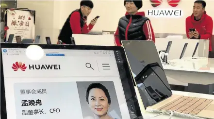  ??  ?? Presa. Perfil de Meng Wanzhou em uma loja da Huawei em Pequim: prisão pode piorar crise entre China e EUA
