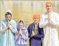  ?? NARINDER NANU/AFP ?? Prime Minister Justin Trudeau, along with his wife, Sophie Gregoire, and his children, pay respects at the Sikh Shrine Golden temple in Amritsar, India, last week.