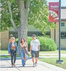  ?? ?? Pueblo Community College students Celina Montez, left, Josette Escobar and Andrew Matrinez walk through the campus quad on Aug. 24, 2022.