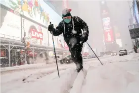  ??  ?? Steve Kent skis through Times Square during a snowstorm, Monday, Feb. 1, 2021, in the Manhattan borough of New York. (AP Photo/John Minchillo)