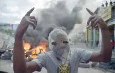  ?? — AFP ?? A masked demonstrat­or gestures during protests in Port-au-prince.