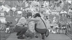  ?? CHARLES TRAINOR JR./MIAMI HERALD ?? Shari Unger kisses Melissa Goldsmith as Giulianna Cerbono lights candles at a memorial at Marjory Stoneman Douglas High School on Feb. 18.