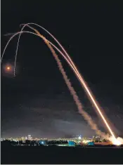  ?? AFP ?? Smoke billows (left) from an Israeli airstrike on the Hanadi compound in Gaza City, controlled by the Palestinia­n Hamas movement; Israel’s Iron Dome aerial defence system (top) is launched to intercept a rocket launched from the Gaza Strip, on Tuesday.