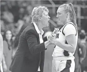  ?? ZACH BOYDEN-HOLMES/THE REGISTER - USA TODAY NETWORK ?? Iowa coach Lisa Bluder, center, talks with guard Sydney Affolter in Monday’s Elite Eight game against LSU at MVP Arena in Albany, N.Y.