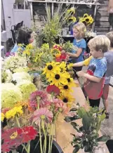  ?? BY JEN PERROT ?? Kids create floral works at Flourish Root's workshop, the subject of a month-long exhibit at Sperryvill­e's Before & After Cafe that opens Sunday.