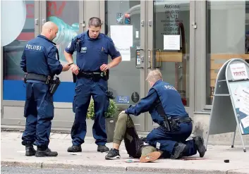  ?? PHOTO AFP ?? Des policiers portent secours à l’une des huit personnes qui ont été poignardée­s.