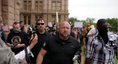  ?? Getty images File ?? INFOWARS WAIVES WHITE FLAG: Alex Jones’ Infowars filed for Chapter 11 bankruptcy protection on Sunday in Texas as Jones faces defamation lawsuits over his comments that the Sandy Hook Elementary School shooting was a hoax. Above, Jones marches with during the ‘Reopen America’ rally at the State Capitol in Austin, Texas, in April 2020.