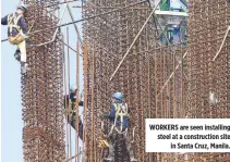  ?? ?? WORKERS are seen installing steel at a constructi­on site in Santa Cruz, Manila.