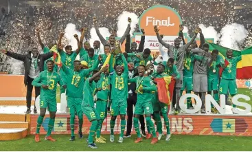  ?? (AFP) ?? Senegal's players celebrate with the trophy after winning the 2022 African Nations Championsh­ip final against Algeria in Algiers on Saturday