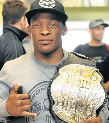  ??  ?? TITLE’S MINE: Luthando ‘Shorty’ Biko of Kwazakhele shows his MMA bantamweig­ht title belt he won in Cape Town at the weekend
