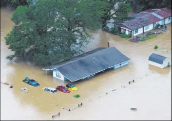  ?? TED JACKSON/THE TIMES-PICAYUNE ?? Homes are flooded Saturday along the Tangipahoa River near Robert, La. At least three people were killed in flooding across the state.