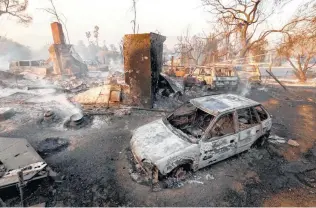  ?? Al Seib / Los Angeles Times ?? Fire smolders in a destroyed home in Thousand Oaks, Calif., on Friday as wildfires continue to ravage the state. Officials put the total number of people forced from their homes at 250,000.