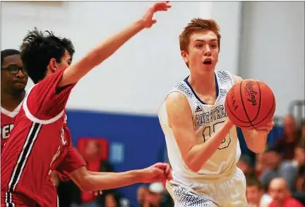  ?? DAVID TURBEN — THE NEWS-HERALD ?? Madison’s Chris Blauman passes the ball during the Blue Streaks’ win over Perry Feb. 23..