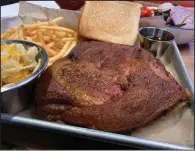  ?? (Arkansas Democrat-Gazette/Eric E. Harrison) ?? The end of a slab of ribs, a half rack, provides extra meat for one of The Library Kitchen + Lounge’s three Meat and Three options, with sides of (clockwise from left) mac and cheese, shoestring fries and a side salad.
