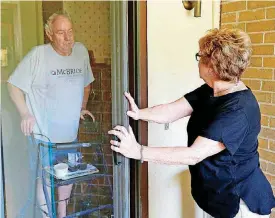  ??  ?? ABOVE: Volunteer Kaye Poos delivers a meal to a client as she makes her rounds for Edmond Mobile Meals.