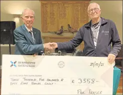  ?? ?? Faversham Golf Club’s 2020 club captain, Paul Fraser, hands a cheque over to Air Ambulance Kent Surrey Sussex volunteer Paul Butt