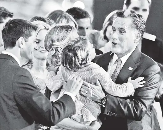  ??  ?? EMBRACEABL­E YOU: Paul Ryan and Mitt Romney are joined by their families onstage last night after Romney’s acceptance speech.