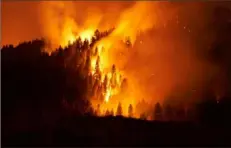  ?? Allison Dinner/Getty Images/TNS ?? The Dixie Fire pushes through the Genesee Valley on Aug. 21, in Genesee, Calif.