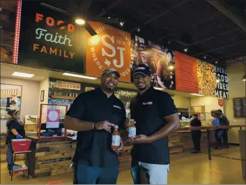  ?? JORDYN COURTNEY — SMOKEY JOHN’S VIA AP ?? Juan Reeves, VP of Smokey John’s BBQ, left, and his brother Brent Reeves, President of Smokey’s John’s BBQ, hold bottles of their famous barbecue sauce, which is available by mail order, at Smokey John’s BBQ in Dallas on Dec. 10.