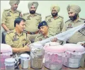  ?? SAMEER SEHGAL/HT ?? Police with ₹30.8 lakh and firearms recovered from the accused during a press conference in Amritsar on Saturday.