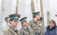  ?? AP ?? East German border guards stand in front of segments of the Berlin Wall in 1989, which were removed to open the wall at Potsdamer Platz passage in Berlin.