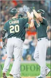  ?? BOB LEVEY — GETTY IMAGES ?? Chad Pinder, right, gets high fives from A’s teammates Mark Canha and Matt Chapman after Pinder hit a fourth-inning home run.