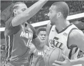  ?? GASTON DE CARDENAS/AP ?? Heat forward James Johnson works defensivel­y Sunday against Jazz center Rudy Gobert.