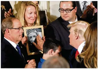  ?? PABLO MARTINEZ MONSIVAIS / ASSOCIATED PRESS ?? President Donald Trump touches a photo of Adam Moser, son of Jeanne Moser of East Kingston, N.H., during Thursday’s event declaring the opioid crisis a national public health emergency.