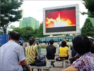  ?? KIM WON-JIN/AFP ?? People watch as coverage of an ICBM missile test is displayed on a screen in a public square in Pyongyang on July 29.