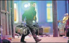  ?? AP ?? An armed police officer recovers medical bags near the scene of a stabbing in Streatham High Road, London.