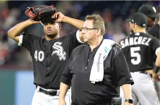 ??  ?? Right- hander Reynaldo Lopez, who was making his second start for the Sox, walks off the field with trainer Herm Schneider in the fifth inning Thursday. | TONY GUTIERREZ/ AP