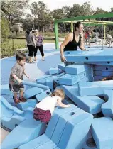  ??  ?? Laura Morris, center, helps children with large foam blocks. Kids use the blocks to make forts or other structures they might think up.