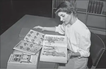  ?? Associated Press ?? RUTH PARRINGTON, a librarian at the Chicago Public Library, is shown in an undated photo poring over Sears Roebuck catalogs. The company’s catalogs once were ubiquitous in American households.