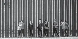  ?? JOHN MOORE/GETTY ?? Immigrants walk Thursday along the border wall that separates El Paso, Texas, from Ciudad Juarez, Mexico. More than 100,000 migrants attempted to cross the border into the U.S. last month — the most since March 2019 under former President Trump.