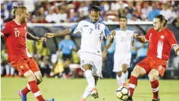  ??  ?? FRISCO: Honduras midfielder Carlos Discua (7) shoots between Canada defender Marcel de Jong (17) and midfielder Samuel Piette (6) during the first half of a CONCACAF Gold Cup soccer match Friday, in Frisco, Texas. — AP