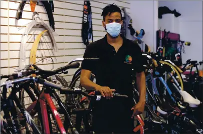  ?? PHOTOS BY CHARLES KRUPA — THE ASSOCIATED PRESS ?? Noah Hicks, owner of Spokehouse Bikes in the Upham’s Corner neighborho­od of Boston, poses at his shop. Many from outside Boston have donated to and shopped at the store which was robbed and vandalized earlier in the month.