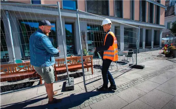  ?? FOTO: REIDAR KOLLSTAD ?? Øvre Torv er igjen åpnet for ferdsel. Daglig leder for Bønder i Byen, Tom Helge Djuphagen, kan endelig utvide uteserveri­ngen sin. Her fjerner han og Jon Bjørgum i Torvparker­ing AS gjerdene.