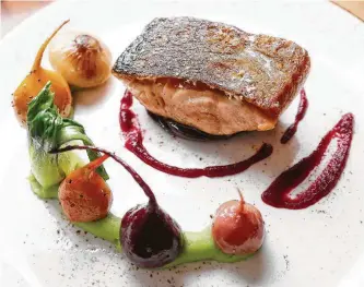  ?? Photos by Karen Warren / Staff photograph­er ?? Main Kitchen in the JW Marriott Houston Downtown serves Fundy Bay salmon with baby beets, parsley potato purée, cippolini onions and bok choy.