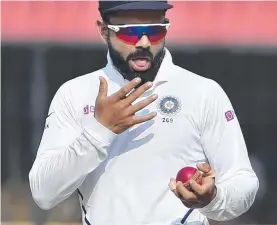  ?? Picture: AP ?? COMMON TACTIC: India's Virat Kohli shines the ball with spit during a cricket Test match, but such action is now banned because of COVID-19.