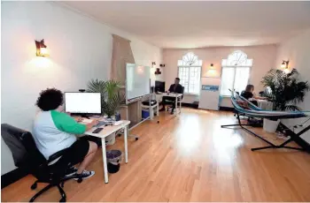  ?? RICK WOOD / MILWAUKEE JOURNAL SENTINEL ?? Amanda DoAmaral, Tan Ho and Claire McHale work in the office area created in one of the living room spaces of their apartment.