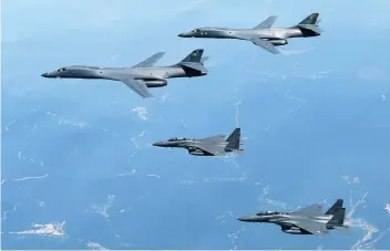  ?? SOUTH KOREAN DEFENSE MINISTRY VIA AP ?? SHOW OF FORCE. In this June 20 photo, U.S. Air Force B-1B bombers, top, and second from top, and South Korean fighter jets F-15K fly over the Korean Peninsula, South Korea in a show of force against North Korea, officials said.