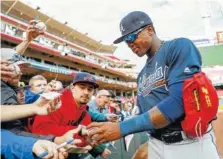  ?? AP PHOTO BY JOHN MINCHILLO ?? Atlanta Braves center fielder Ronald Acuna Jr. signs autographs before the team’s game against the Cincinnati Reds on Wednesday.