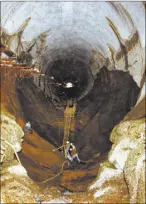  ?? COURTESY BUREAU OF RECLAMATIO­N ?? Workers on Sept. 14, 1983, examine a hole carved in the spillway and bedrock at Glen Canyon Dam by record flows on the Colorado River. The same flood event also damaged the spillways at Hoover Dam, though not to this extent.