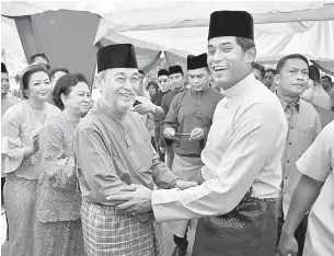  ?? — Gambar Bernama ?? RUMAH TERBUKA: Khairy (kanan) bersalaman dengan Tun Abdullah pada Majlis Rumah Terbuka Aidilfitri beliau di pekarangan Sekolah Menengah Agama Haji Mohd Yatim, Kota, Rembau, semalam.