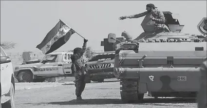  ?? -AFP ?? A Turkey-backed Syrian rebel fighter holds the Syrian opposition flag near the border town of Tel Abyad, Syria.